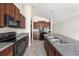 Spacious kitchen boasts black appliances, granite countertops and brown cabinets, with ample storage at 7211 Ozello Trail Ave, Sun City Center, FL 33573