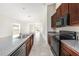 Well-lit kitchen features stainless sink, granite countertops, brown cabinets, and black appliances at 7211 Ozello Trail Ave, Sun City Center, FL 33573