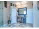 A vanity with a dark wood base and granite countertops complements the travertine floors in this luxurious bathroom at 7301 Loghouse Rd, Plant City, FL 33565