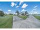 Lush front lawn with long circular driveway and a beautiful home with mature palm trees at 7301 Loghouse Rd, Plant City, FL 33565