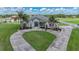 Elegant home with a circular driveway, lush lawn, mature palm trees and landscaped garden beds at 7301 Loghouse Rd, Plant City, FL 33565