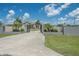 Elegant home entrance featuring an iron gate, surrounded by manicured lawns and landscaping at 7301 Loghouse Rd, Plant City, FL 33565