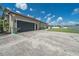 Spacious garage, complemented by a well-maintained lawn and landscaping, set under a clear blue sky at 7301 Loghouse Rd, Plant City, FL 33565