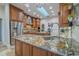 Open kitchen with granite countertops, custom cabinets, and stainless steel appliances at 7301 Loghouse Rd, Plant City, FL 33565