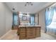 This main bedroom features wood accents, blue drapes, and a tray ceiling at 7301 Loghouse Rd, Plant City, FL 33565