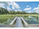 Picturesque pond with a wooden pier and lush water lilies, creating a serene and natural backdrop at 7301 Loghouse Rd, Plant City, FL 33565