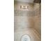 A neutral tiled shower features decorative tile inlay and built in niche at 7301 Loghouse Rd, Plant City, FL 33565