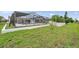 Large grassy backyard featuring a screened-in pool enclosure and a white perimeter fence at 734 Flamingo Dr, Apollo Beach, FL 33572