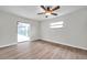 Light-filled bedroom with a ceiling fan, wood-look floors and a view of the screened-in porch at 734 Flamingo Dr, Apollo Beach, FL 33572