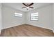 This bright bedroom features neutral walls, wood-look flooring and two windows at 734 Flamingo Dr, Apollo Beach, FL 33572