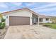 Lovely single-story house with a brown garage door, red roof tiles, and a well-maintained front yard at 734 Flamingo Dr, Apollo Beach, FL 33572