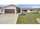 Charming single-story home featuring a brown garage door, red roof tiles and a well manicured front lawn at 734 Flamingo Dr, Apollo Beach, FL 33572