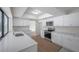 Modern kitchen with white cabinets, quartz countertops, stainless steel appliances and hardwood floors at 734 Flamingo Dr, Apollo Beach, FL 33572