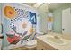 Bright bathroom with colorful shower curtain and white vanity at 7810 Flintlock Dr, Port Richey, FL 34668