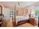 Bedroom featuring a four-poster bed, dresser, and sliding door to the outdoors at 7810 Flintlock Dr, Port Richey, FL 34668