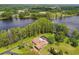 Expansive aerial view of the home set within a wooded property with mature trees, green lawns and a lake nearby at 820 Newberger Rd, Lutz, FL 33549