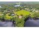 Beautiful aerial view of a lakeside home with lush greenery and a private pool at 820 Newberger Rd, Lutz, FL 33549