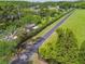 Aerial view of the property showcasing an iron gate, long driveway, landscaped yard, and surrounding lush greenery at 820 Newberger Rd, Lutz, FL 33549
