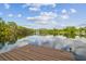 Peaceful lake view from the property's dock, showcasing calm waters reflecting the sky and surrounding trees at 820 Newberger Rd, Lutz, FL 33549