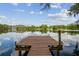 Scenic view of a calm lake with a wooden dock and clear blue skies at 820 Newberger Rd, Lutz, FL 33549