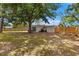 Fenced backyard with a grass lawn, a large tree and the rear view of the home at 8485 Pelican Ln, Seminole, FL 33777