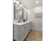 Modern bathroom featuring dual sinks, sleek black fixtures, and stylish vanity lighting at 8485 Pelican Ln, Seminole, FL 33777