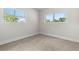 Minimalist bedroom featuring carpet, two bright windows, and neutral tones at 8485 Pelican Ln, Seminole, FL 33777