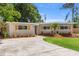 Charming single-story home featuring a well-manicured lawn, gray paint, dark shutters, and a concrete driveway at 8485 Pelican Ln, Seminole, FL 33777