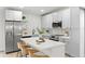 Bright, modern kitchen with stainless steel appliances, island with seating, and white cabinets at 8485 Pelican Ln, Seminole, FL 33777
