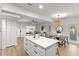 Open floor plan with kitchen island, dining area, and living room featuring neutral color palette at 8485 Pelican Ln, Seminole, FL 33777