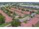Aerial view showcasing single-story homes with red tile roofs, manicured lawns, and tree-lined streets in a well-planned community at 8701 40Th N Ln, Pinellas Park, FL 33782