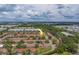 Aerial view of a community with single-story homes featuring red tile roofs and blue awnings amidst lush greenery at 8701 40Th N Ln, Pinellas Park, FL 33782