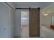 Bathroom entrance featuring sliding barn door and updated tile flooring at 8701 40Th N Ln, Pinellas Park, FL 33782