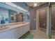 Well-lit bathroom with a double vanity, mirrors, and a separate shower stall at 8701 40Th N Ln, Pinellas Park, FL 33782