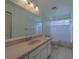 Bathroom features large mirror, white cabinets, and neutral tile at 8701 40Th N Ln, Pinellas Park, FL 33782