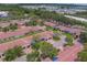 An aerial shot showcases the layout of single-story residences with red tile roofs, interspersed with lush landscaping at 8701 40Th N Ln, Pinellas Park, FL 33782