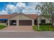Villa showing the driveway leading to the garage, with barrel tile roof and manicured lawn at 8701 40Th N Ln, Pinellas Park, FL 33782