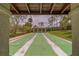 A view of the shuffleboard courts, framed by the structure, showing the green courts ready for play at 8701 40Th N Ln, Pinellas Park, FL 33782