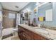Modern bathroom with a double sink vanity, granite countertop, and a tiled shower-tub combination at 9056 108Th Ave, Seminole, FL 33777