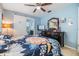 Comfortable bedroom features floral bedding, dresser with a mirror, and a sliding barn door leading to the ensuite bathroom at 9056 108Th Ave, Seminole, FL 33777