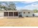Home exterior featuring a sunroom, well-maintained lawn, and mature trees at 9056 108Th Ave, Seminole, FL 33777