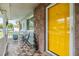Inviting front porch with a yellow door and cozy seating area at 9056 108Th Ave, Seminole, FL 33777