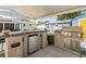 Built-in outdoor kitchen with stainless steel grill, mini-fridge, and ample counter space at 9056 108Th Ave, Seminole, FL 33777