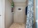 Modern tiled walk-in shower featuring a shower curtain, shelving, and neutral-colored tile at 9056 108Th Ave, Seminole, FL 33777