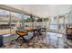 Enclosed sunroom with beautiful tile floors, comfortable seating, and backyard views through large windows at 9056 108Th Ave, Seminole, FL 33777