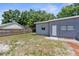 Backyard view of a single story home with a wooden fence and some mature trees at 9310 N 12Th St, Tampa, FL 33612
