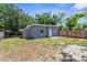 A fenced backyard of a single story home features some patchy grass and mature trees at 9310 N 12Th St, Tampa, FL 33612
