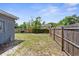 A long, fenced backyard of a house with patchy grass and mature trees at 9310 N 12Th St, Tampa, FL 33612
