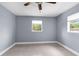Clean bedroom with light walls, ceiling fan, neutral-colored tile flooring, and a window at 9310 N 12Th St, Tampa, FL 33612