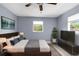 Comfortable bedroom features a ceiling fan, large window, and a decorative painting above the bed at 9310 N 12Th St, Tampa, FL 33612